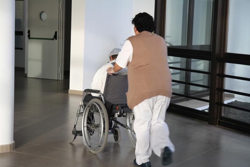 Un anciano es trasladado por una auxiliar en la residencia de Afa en Tahíche, esta semana.