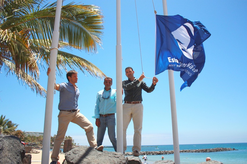 La bandera de las Estaciones Náuticas es izada en la playa de Las Cucharas.