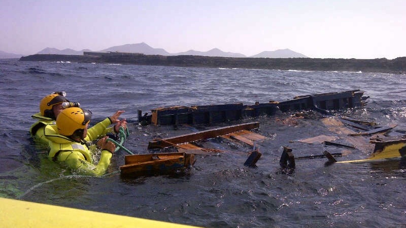 Efectivos de Emerlan rescatando la patera, en la mañana de este martes.