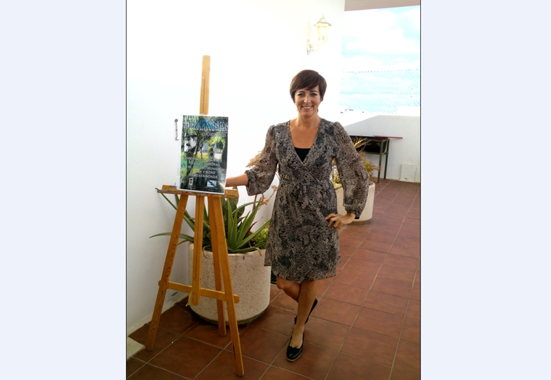 La escritora y fotógrafa Pepa González posa al lado del cartel de presentación.