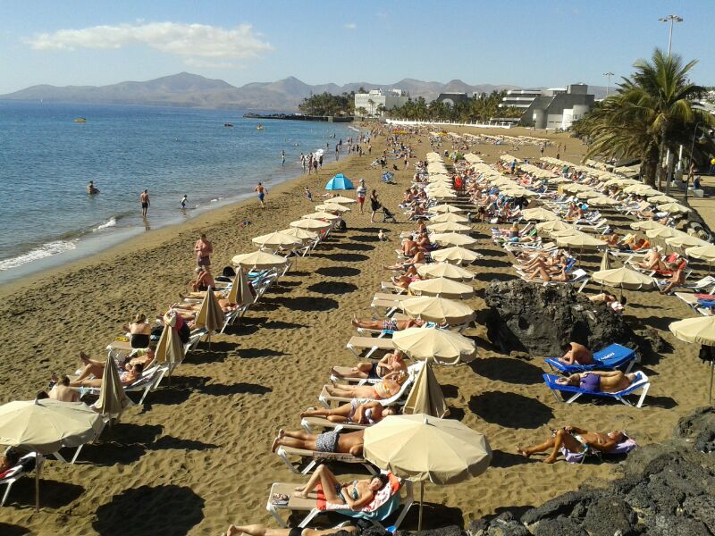 Residentes y turistas disfrutan de la playa en Puerto del Carmen.